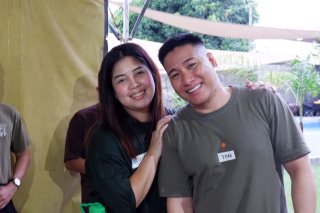 Two friends smiling for the camera under a tent